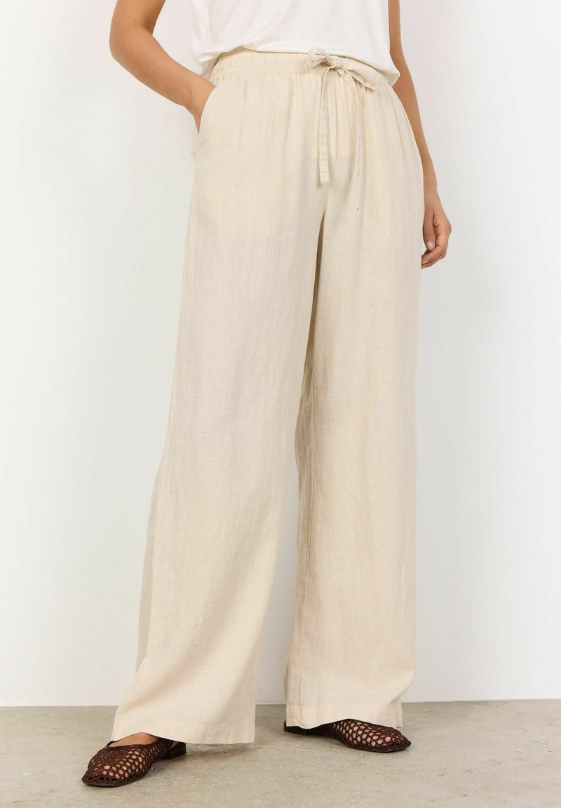 Beige wijde broek met een verstelbare tailleband, voorzien van zijzakken en een lichtgewicht, gestructureerde stof die tot de vloer valt.