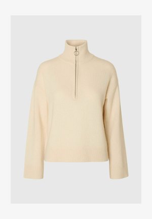 Pull en crème à col montant avec demi-fermeture éclair, ourlets et poignets côtelés, fabriqué en matière tricotée douce, offrant une coupe décontractée et un design minimal.