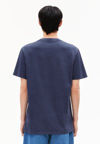 Marineblauwe katoenen t-shirt met een ontspannen pasvorm, korte mouwen en een ronde hals. Glad textuur met minimale stikdetails aan de zoom.