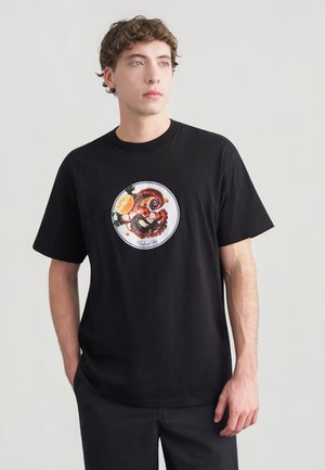 Zwart katoenen T-shirt met een ronde afbeelding van een octopus, citroen en groen blad. Korte mouwen en een losse pasvorm.