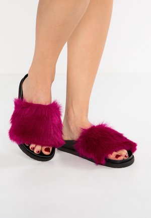 Fuchsia pels-sandaler med blød tekstur og brede stropper, med sorte gummisåler og åbne tæer.