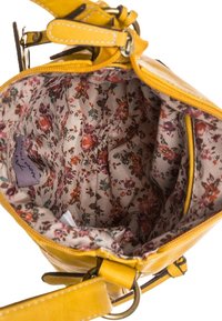 Borsa a mano gialla in pelle con fodera in tessuto a motivo floreale. Presenta una chiusura con zip e una tracolla regolabile per maggiore versatilità. Comparti interni visibili.