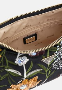 Czarny materiałowy woreczek z kwiecistą haftem w różnych kolorach i cekinami. Wnętrze wyłożone beżową podszewką z nadrukowanym logo marki oraz kieszenią na zamek.