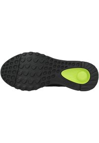 Suola di scarpa nera con design in gomma testurizzata, caratterizzata da modelli di grip circolari e un accento verde vicino al tallone per una maggiore aderenza.