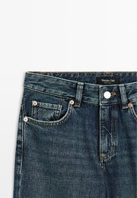 Jeans in denim blu scuro con un design classico, dotati di chiusura con bottoni, cinque tasche e dettagli in tonalità rame. L'etichetta riporta "Massimo Dutti."