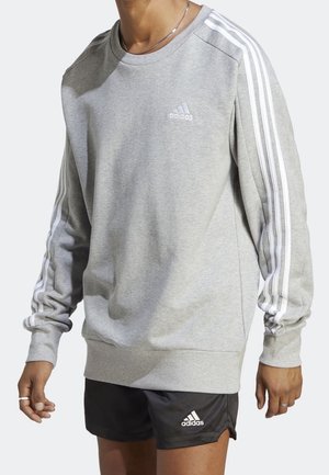 Grauer Pullover mit weißem Adidas-Logo auf der Brust, mit drei weißen Streifen entlang jedes Ärmels. Weicher Stoff, Rundhalsausschnitt.