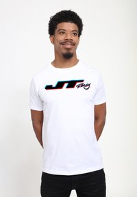 Bílý bavlněný tričko s černým a modrým logem "JT Racing" na hrudi, krátké rukávy a kulatý výstřih.
