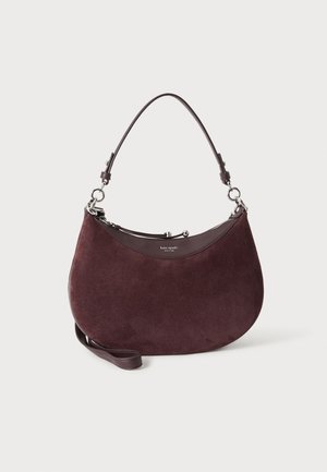 Sac à main demi-lune en daim bordeaux avec garniture en cuir, poignée courte, bandoulière détachable et petit logo Kate Spade au centre devant.