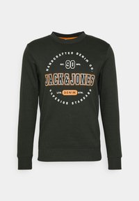 Felpa crewneck verde scuro con logo "Jack & Jones" in bianco e arancione, che presenta il testo "Handcrafted Denim Co." e "Superior Standard".