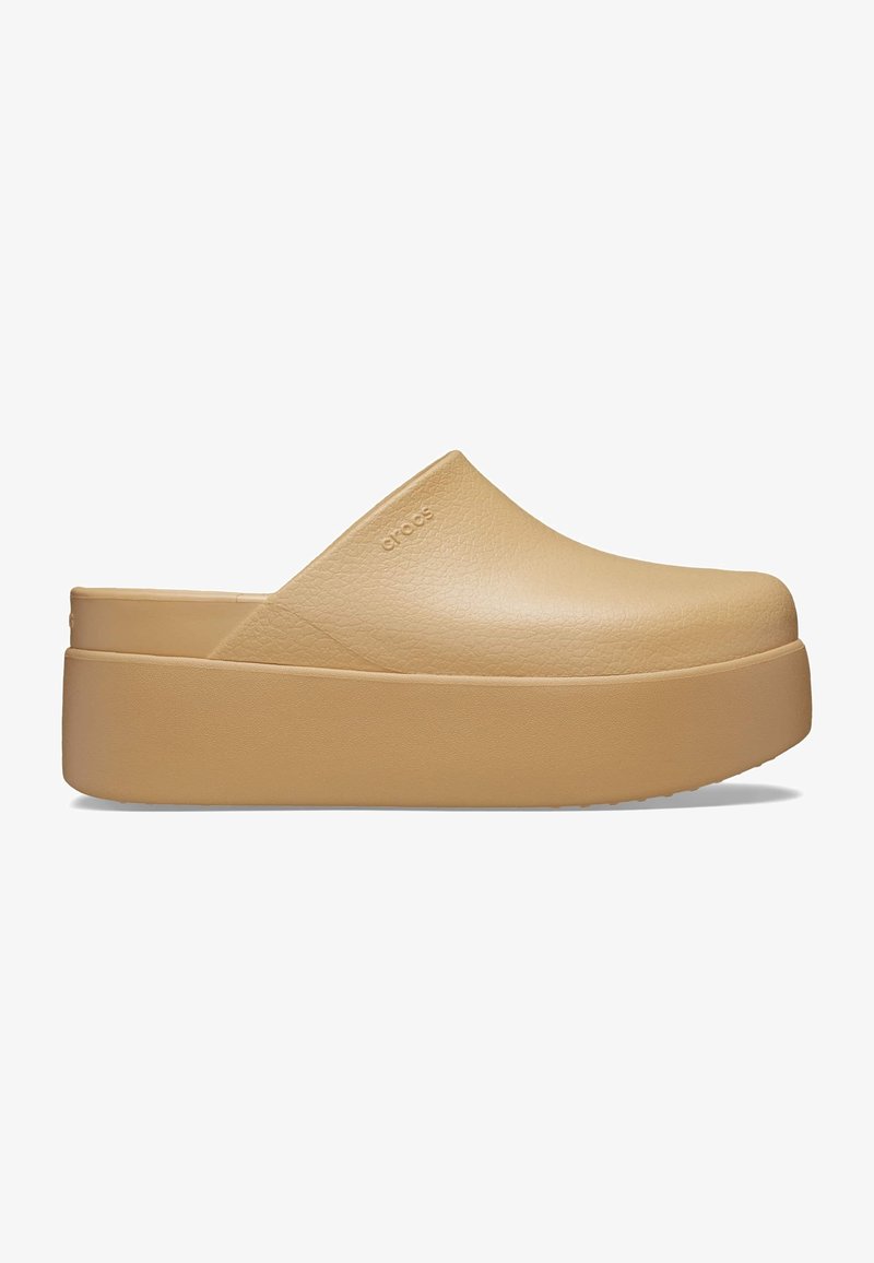 Sabot compensé beige à enfiler avec une tige texturée, bout fermé, dos ouvert et semelle épaisse, marqué d'un subtil logo Crocs.