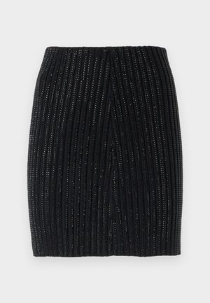 Jupe mini en tricot noir avec nervures verticales et fils métalliques subtils. Elle présente une coupe ajustée et une fente centrale au dos pour plus de liberté de mouvement.