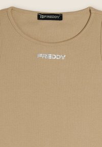 Top in beige con scollo rotondo, tessuto testurizzato e logo argento con il nome del marchio "FREDDY" centrato sul petto.