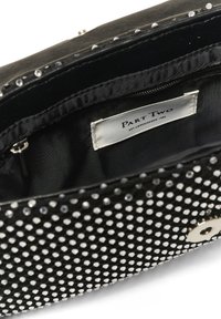 Sort clutch-taske med en glat tekstur, dækket af sølvfarvede dekorerende nitter. Har en lynlåslukning og et indvendigt mærke.