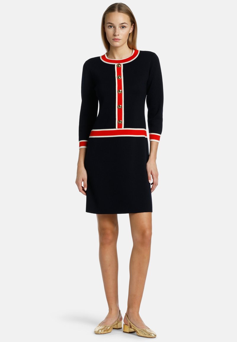 Navy knit dress with a round neckline, red and white striped accents, and gold buttons down the front. Short sleeves and fitted silhouette.