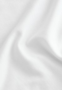 Hvid bomuldsstof med en glat, let tekstureret overflade, der viser bløde foldninger og subtile variationer i lys og skygge.