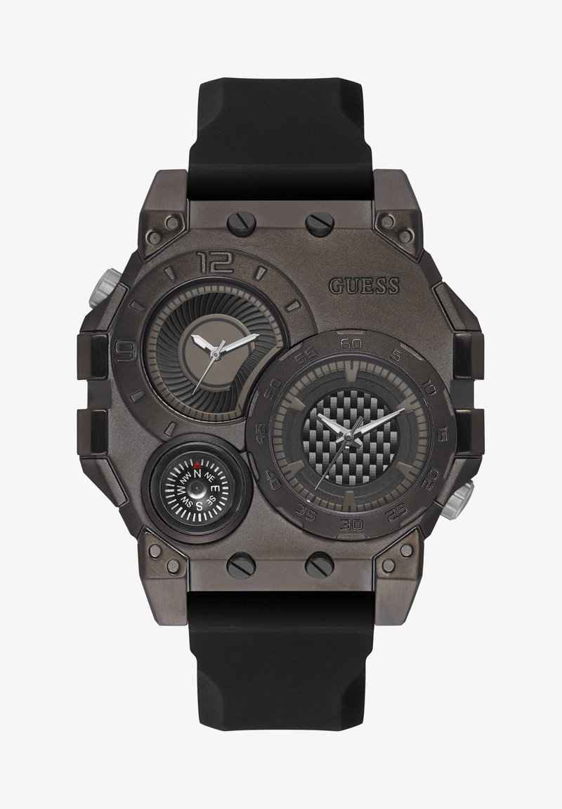 Bronzefarbene Guess-Armbanduhr mit großem quadratischen Gehäuse, schwarzem Gummiband, drei Zifferblättern und einem Kompass, mit strukturierten Akzenten.