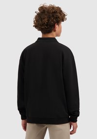 Zwarte pullover sweatshirt met een kraag en een relaxte pasvorm, met lange mouwen en geribbelde boorden. Gemaakt van een zachte, gestructureerde stof.