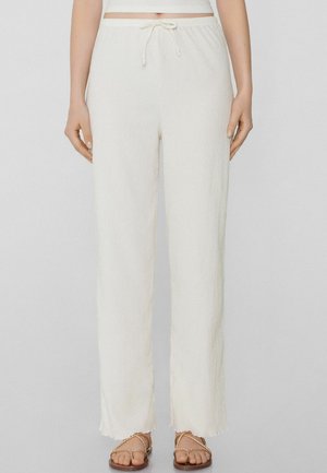 Pantaloni ampi bianchi, texture, con vita elasticizzata e coulisse. Presentano orli grezzi e una vestibilità comoda.