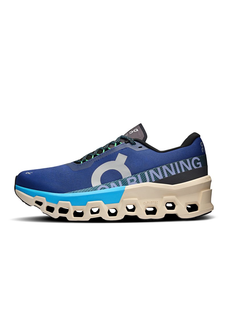 Running shoe with a blue mesh upper, black accents, large logo, and a distinctive cream-colored sole featuring hexagonal cutouts.