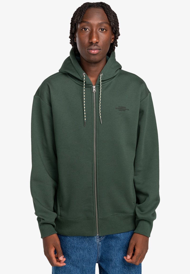 Grøn zip-up hættejakke lavet af blødt materiale, med foret hætte, frontlynlås og strikkede snore med metalspidser.