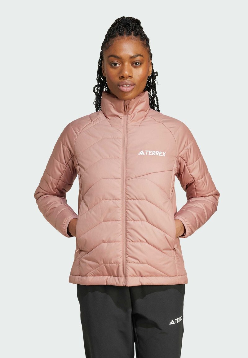 Veste isolante rose clair avec un col montant, un motif matelassé en diagonale et le logo blanc "TERREX" sur la poitrine gauche.
