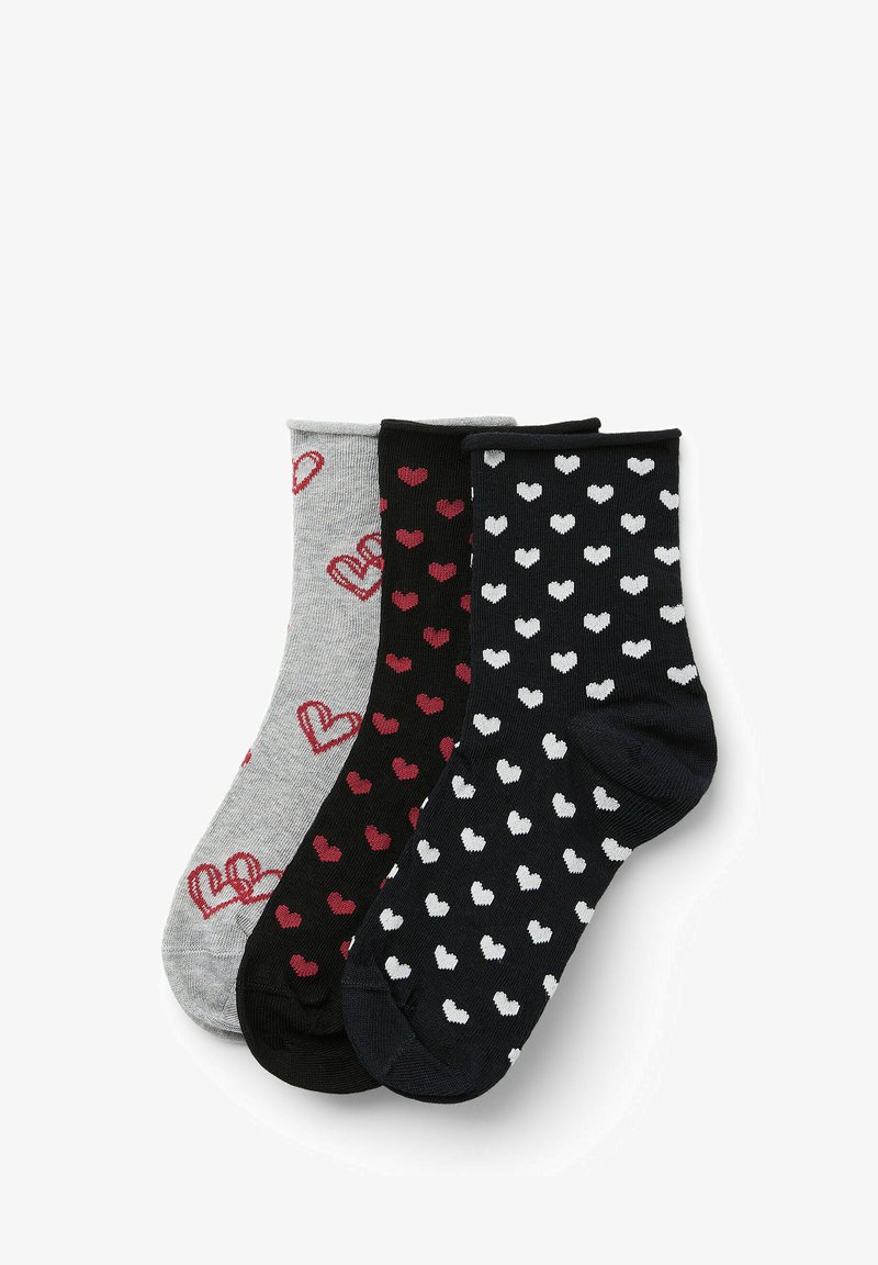 Trois paires de chaussettes de cheville : grises avec des cœurs rouges, noires avec des cœurs blancs et noires unies. Tissu doux, motif tricoté et couleurs contrastées.
