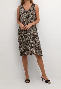 Ärmelloses Kleid mit Leopardenmuster, V-Ausschnitt, aus leichtem Stoff und lockerer Passform, mit knielanger Länge und zarten Raffungselementen.