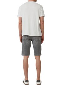 Witte korte mouwenshirt met een ronde halslijn, gecombineerd met grijze denim shorts. De shorts hebben een klassieke snit en zichtbare stikseldetails.