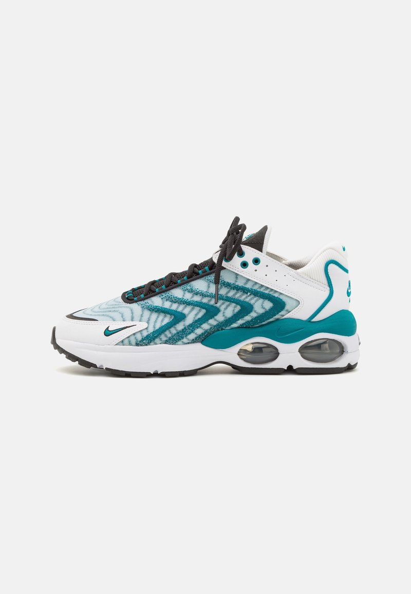 Baskets de sport unique avec motif zigzag bleu sarcelle et blanc, semelle blanche, lacets noirs et coussins d'air visibles au talon.
