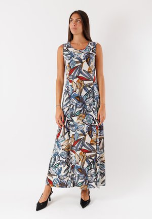 Abito lungo con stampa floreale in blu, rosso e marrone su uno sfondo bianco, con scollatura tonda e design senza maniche, abbinato a tacchi neri.