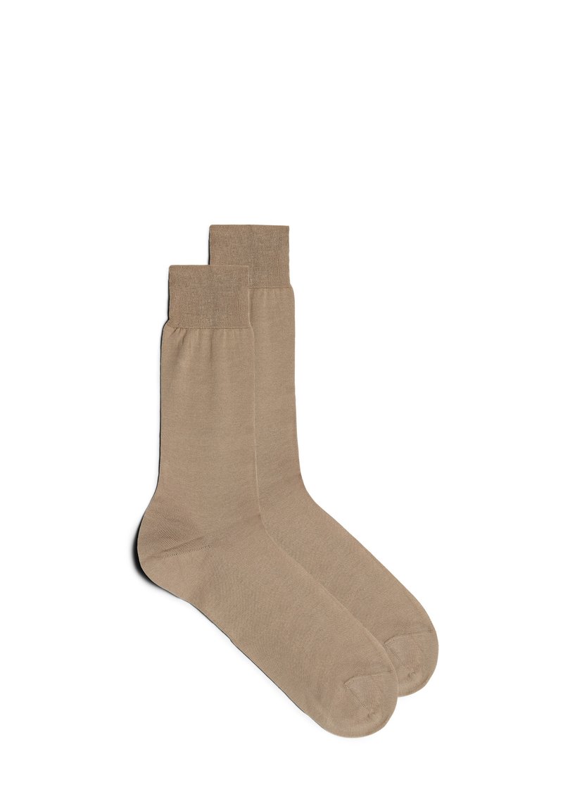 Beige ankelstrumpor i mjukt material, med ribbade muddar och en enkel design. Texturen är mjuk, utan synliga mönster eller detaljer.