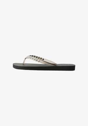 Flip-flop with a black rubber sole, transparent straps adorned with silver studs, and a smooth textured footbed.