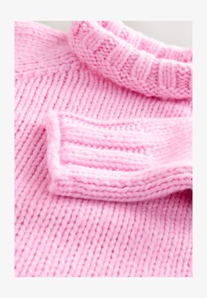 Pletena ružičasta majica s rebrastim izrezom, s grubom teksturom i ravnim tijelom. Manžete imaju dizajn presavijenog ruba.