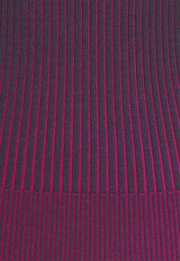 Faltstoff in dunklem Marineblau und magentafarbenen Streifen, mit einer strukturierten Oberfläche, die schmale und breite Abschnitte aufweist und ein markantes Muster kreiert.