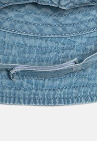 Blå denim bøttehatt med myk tekstur, med broderte detaljer og brettet brem. Inkluderer en indre stoffbånd for justering av passform.