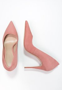 Escarpins en daim rose à bout pointu, avec un talon aiguille fin et une doublure intérieure lisse. Présentent un design sans couture et une esthétique minimaliste.