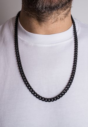 Black chain necklace with interlocking links, worn over a white t-shirt. The links have a smooth, shiny texture and a consistent thickness.