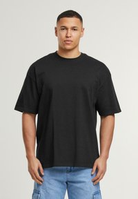 Black cotton t-shirt with a crew neck and short sleeves, featuring a relaxed fit and smooth texture. Suitable for casual wear.