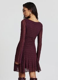 Bordeauxrotes Spitzenkleid mit langen Ärmeln, enger Taille, ausgestelltem Rock, strukturierter Stoff und einem wellenförmigen Saum.