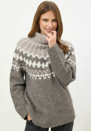 Maglione grigio lavorato a maglia con colletto alto, caratterizzato da motivi geometrici bianchi. La texture sembra morbida e pelosa, con polsini e orlo a costine.