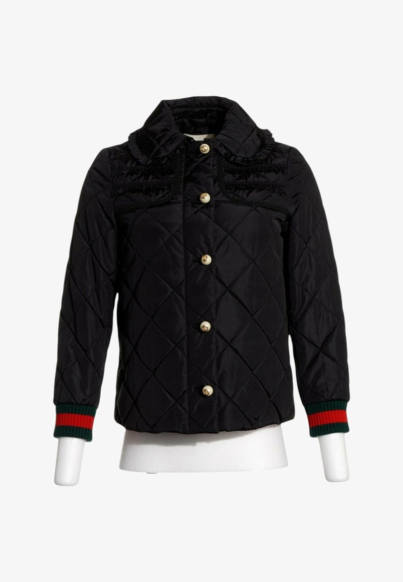 Veste matelassée noire avec col à volants, boutons dorés sur le devant, et poignets côtelés rayés vert-rouge sur les manches longues.