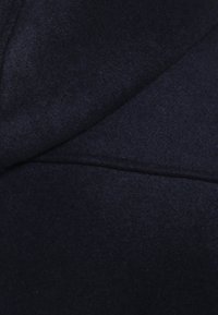 Tessuto di lana blu navy scuro con una texture morbida e sottili pieghe sovrapposte.