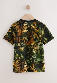 Kurzärmeliges T-Shirt mit schwarzer Grundfarbe und einem lebhaften Muster aus grünen und orangenen Farnblättern. Aus weichem Stoff gefertigt, mit Rundhalsausschnitt.