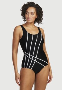 Svart baddräkt i ett stycke med tjocka remmar, prydd med vita vertikala och diagonala linjer, slät tygtextur och rundad halsringning.