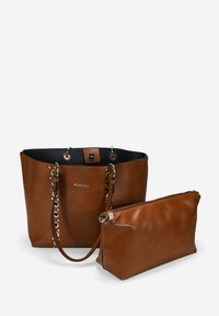 Sac tote en cuir marron avec quincaillerie en argent et détails en œillets sur les côtés, accompagné d'une pochette zippée assortie de taille plus petite.