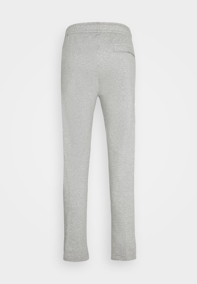 Pantalons de jogging en coton gris avec une taille élastique, un design ajusté et une poche arrière, présentant une texture lisse et un minimum de détails.