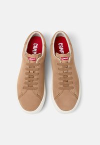 Brązowe zamszowe sneakersy z okrągłym noskiem, białą gumową podeszwą i sześcioma oczkami do sznurowania. Czerwono-biała logo "CAMPE" na wkładce.