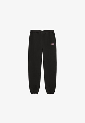 Czarne spodnie dresowe z elastycznym pasem i zwężanymi mankietami, ozdobione małą prostokątną naszywką z logo w kolorach fioletowym i białym.