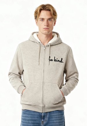 Grauer Reißverschluss-Hoodie mit weichem, weißen Fleece-Futter und gesticktem Text "sei freundlich". Zwei Fronttaschen und Kapuze mit Kordelzug.