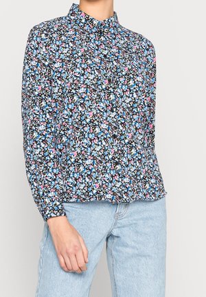 Long-sleeve button-up shirt with blue, pink, and white floral pattern worn with light blue jeans.